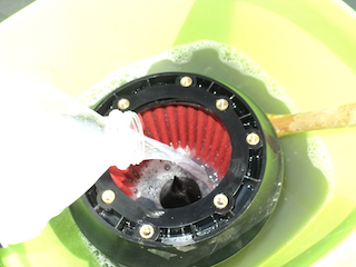 Mettre le filtre a air dans une bassine et faire couler le liquide de l’intérieur vers l'extérieur.